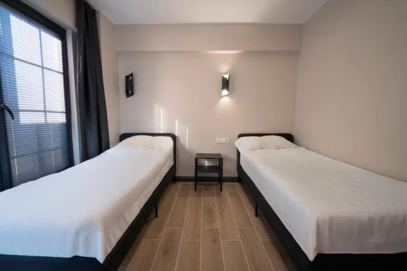 Eight Sapanca otelinde iki tek kişilik yatak bulunan modern yatak odası